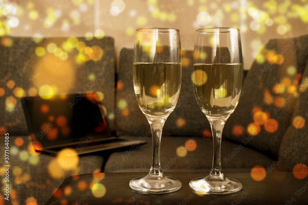 Two glasses of champagne with golden confetti, glitter, serpentine and lights. Night of celebration concept Two glasses of champagne with golden confetti, glitter, serpentine and lights. Night of celebration concept