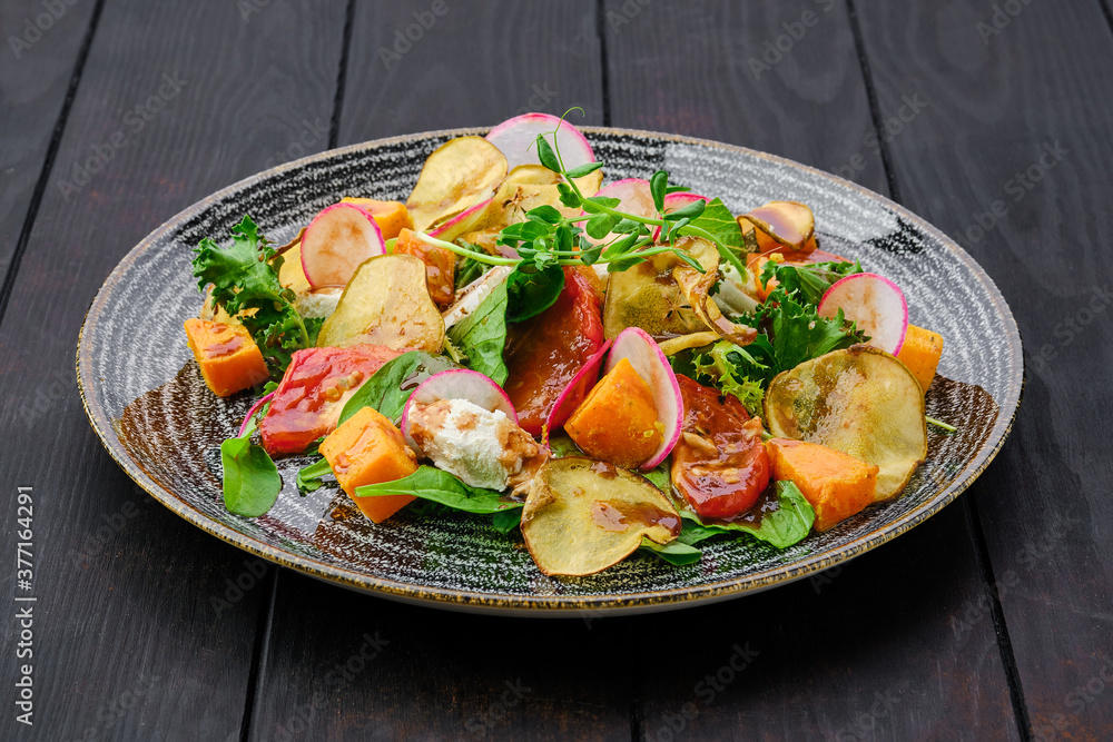 Salad with soft cheese, radish, pear, pumpkin and sun dried tomato