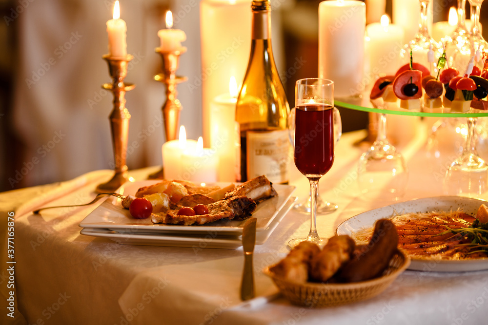Romantic luxury dinner for lovers indoor. Tasty dishes. New year, valentine day or anniversary. Burning candles on the table