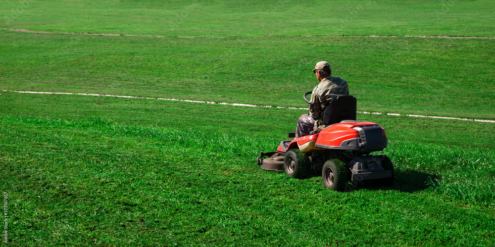 Lawn Mower. The worker cuts the lawn. Lawn Mower. The worker cuts the lawn.