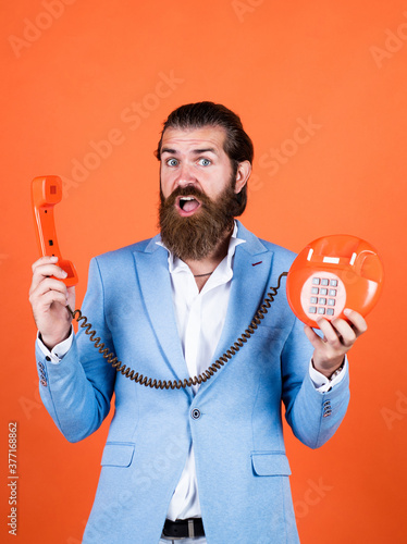 Fellow On The Phone. young man talking on telephone. businessman talking on vintage phone. Male talking on landline phone. vintage technology in modern life. line is busy. Caring first