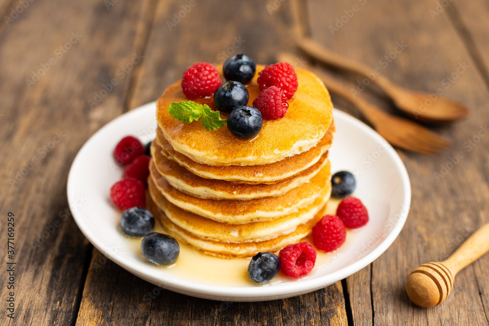 Delicious pancakes with raspberry and blueberry on wooden table. Delicious pancakes with raspberry and blueberry on wooden table.