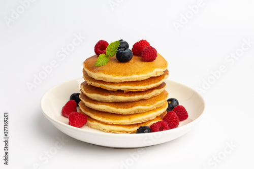 Delicious pancakes with raspberry and blueberry on White background