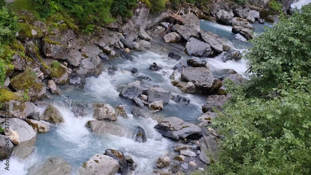 powerful stream of clean water quickly flows along mountain river, splashes scatter from stones, concept of wild nature, symbol of natural resources, alternative energy, water sports powerful stream of clean water quickly flows along mountain river, splashes scatter from stones, concept of wild nature, symbol of natural resources, alternative energy, water sports