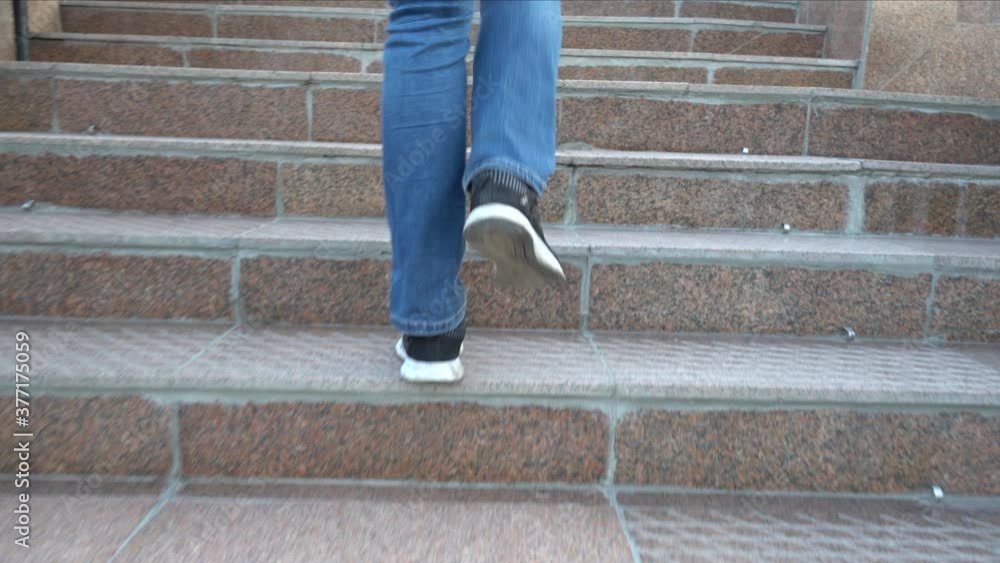 Women's feet in jeans climb the stairs. Step up the stairs. Low angle view. Women's legs in boots and jeans, going up. Walk in the city. Urban landscape. Steps, hurry, walk, move, step. 4k Women's feet in jeans climb the stairs. Step up the stairs. Low angle view. Women's legs in boots and jeans, going up. Walk in the city. Urban landscape. Steps, hurry, walk, move, step. 4k