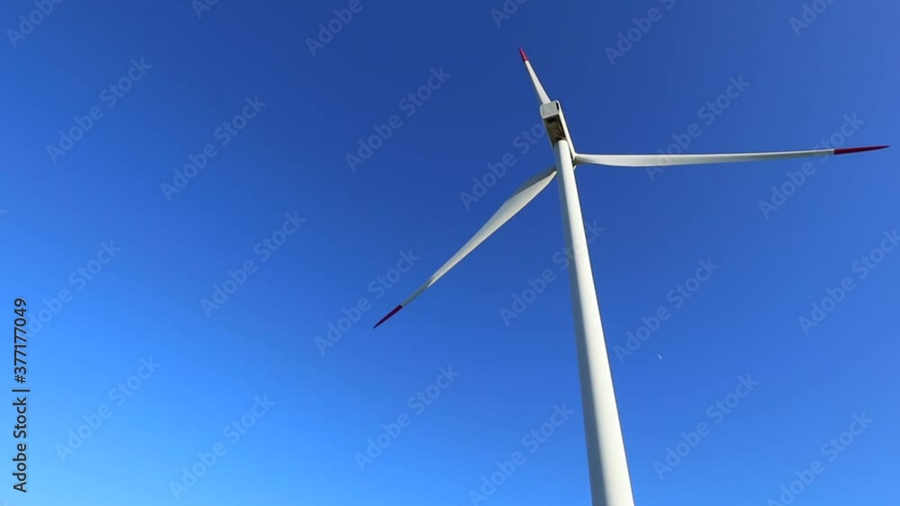 One wind turbine tower, bottom view, energy saving concept. Alternative electricity supply industry, windmill turbine station. One wind turbine tower, bottom view, energy saving concept. Alternative electricity supply industry, windmill turbine station.