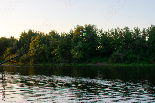 Feeder fishing rod on the sunset background the lake. Carp fishing rod on river. 
