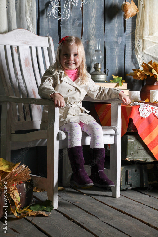 girl sitting on a chair in halloween decorations, smiling and making faces