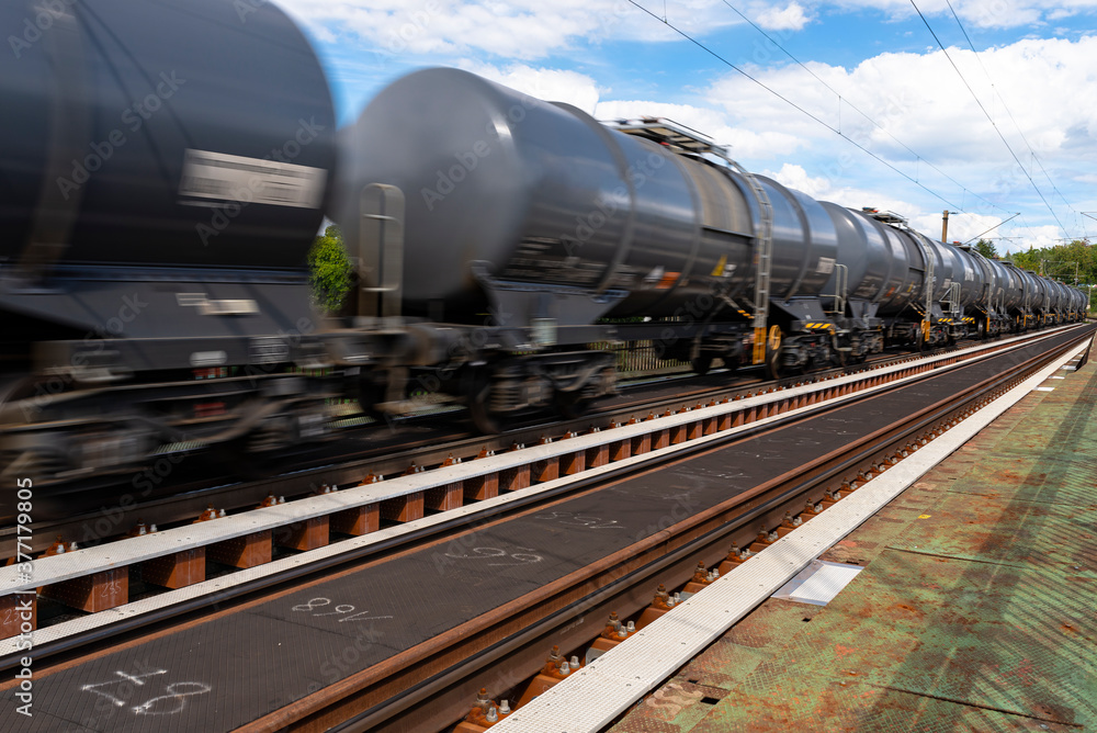 Blurry photo of railroad tank cars in motion, on a metal bridge over the river. Blurry photo of railroad tank cars in motion, on a metal bridge over the river.