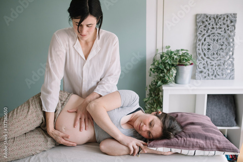 Professional Osteopath Working With Pregnant Caucasian Woman