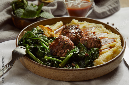 Meatballs served with mashed potato and tomato sauce. photo