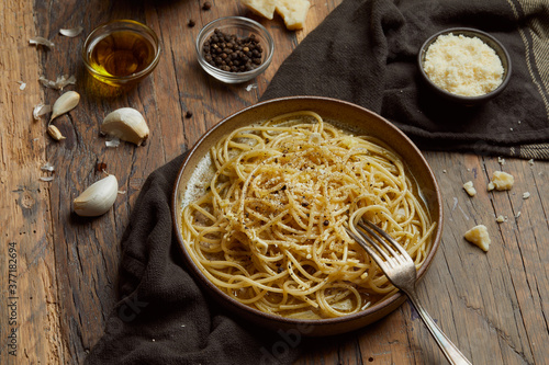 aglio e olio pasta served on a wooden table. photo