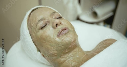 mature woman in beauty clinic getting an anti age facial traetment photo