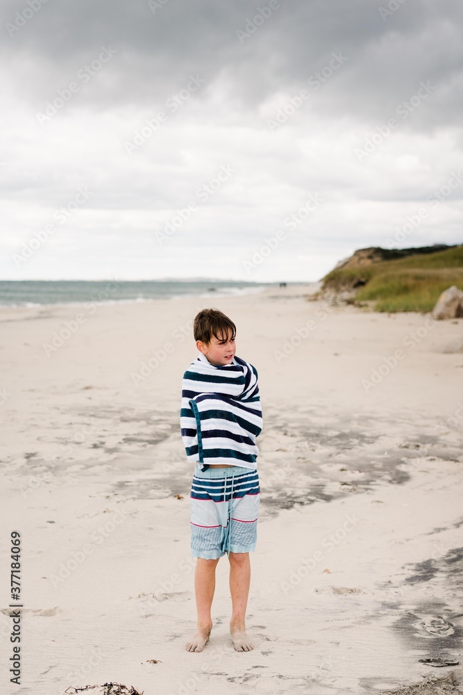 child wrapped in striped towel on the beach child wrapped in striped towel on the beach