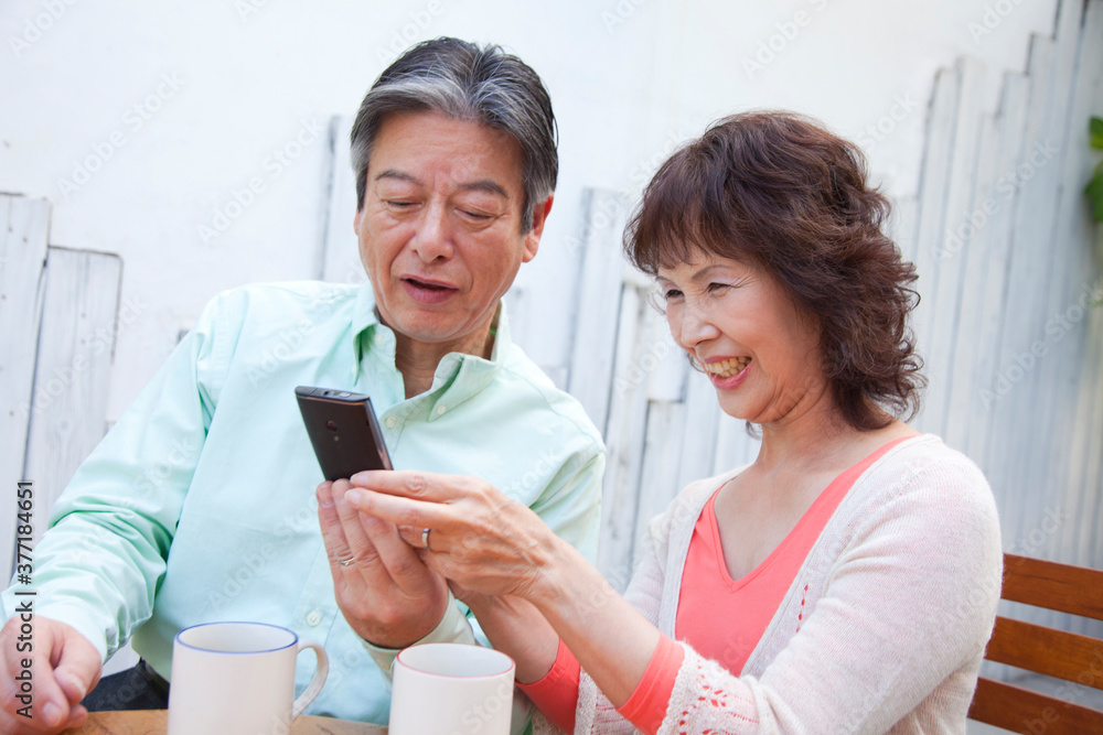 携帯電話を見るシニア夫婦 携帯電話を見るシニア夫婦