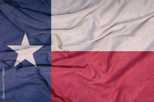 Flag of the American state flies in the wind. Colored background on fabric