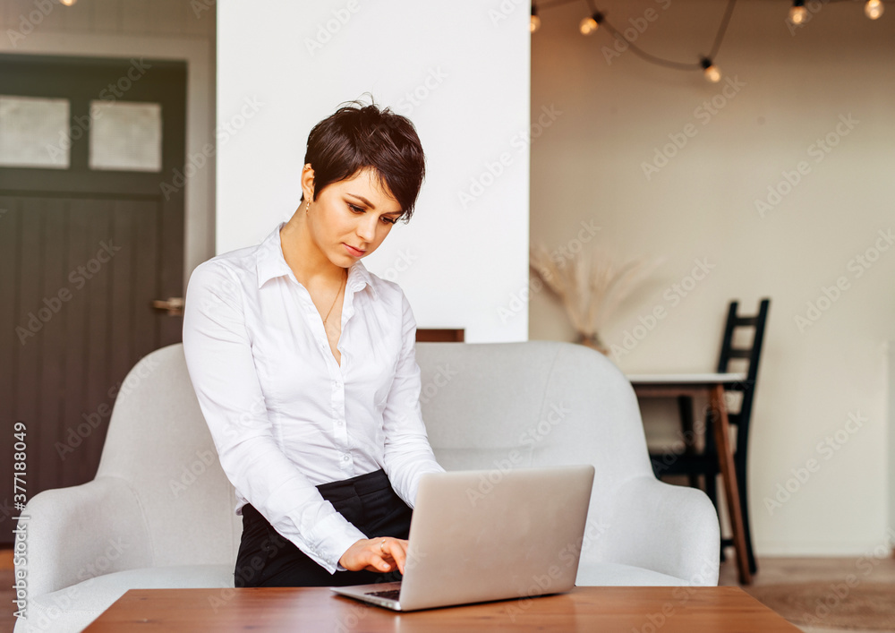 Woman working on laptop at home office, backlit warm light Woman working on laptop at home office, backlit warm light