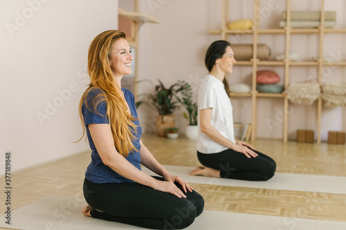 Two adult women practice yoga in a yoga studio photo