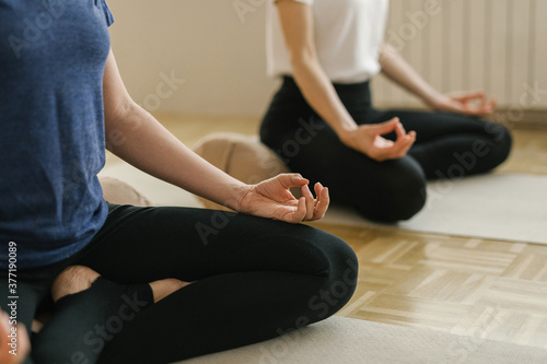 Two adult women practice yoga in a yoga studio photo