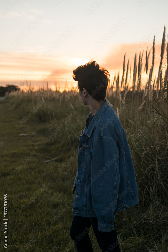 young man on the road with sunset sun on his back, travel concept, trust friends campaign, social media, man advertising young man on the road with sunset sun on his back, travel concept, trust friends campaign, social media, man advertising