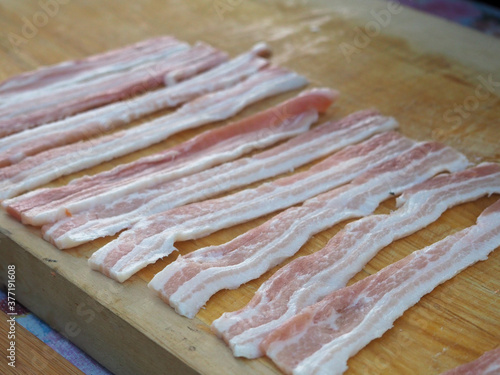 raw sliced bacon on a wooden Board. appetizing slices of bacon