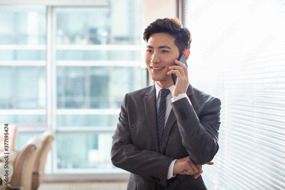Confident businessman using smartphone in office Confident businessman using smartphone in office