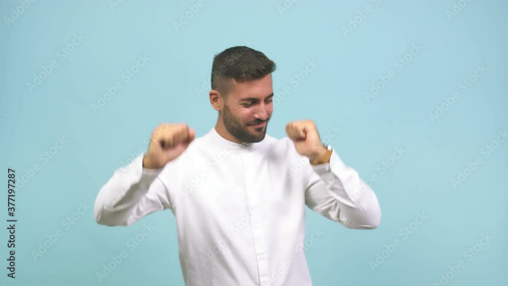 Young caucasian handsome man dancing and having fun, moving arms listening to music Young caucasian handsome man dancing and having fun, moving arms listening to music