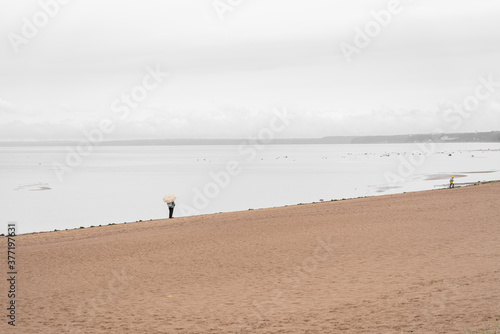 A man with umbrella on rainy seashore