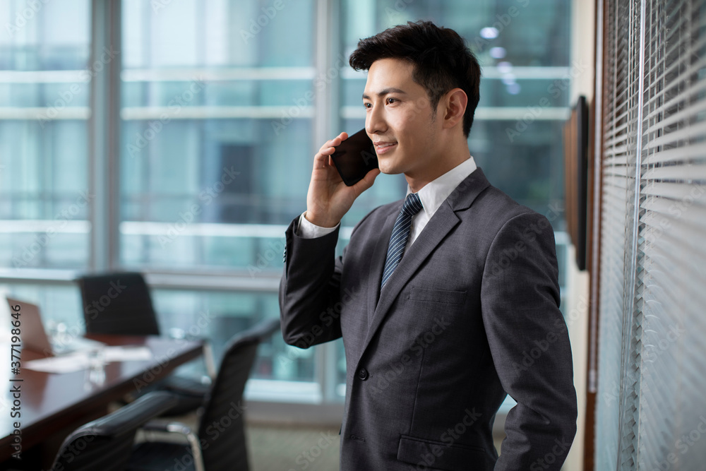 Confident businessman using smartphone in office Confident businessman using smartphone in office