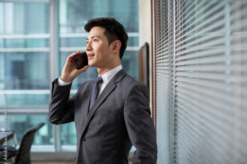 Confident businessman using smartphone in office Confident businessman using smartphone in office