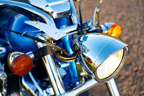 Chrome motorcycle headlight close-up. © Dmytro
