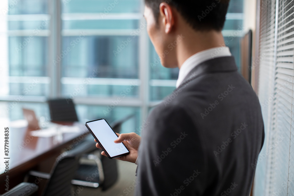 Confident businessman using smartphone in office Confident businessman using smartphone in office