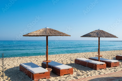 Sun Beds with shades covering from the hot summer sun in Ikaria beach  Greece