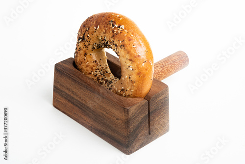 A Freshly Baked Bagel On A Wood Slicing Stand