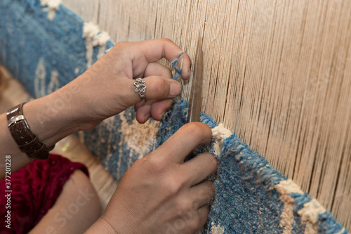 Woman hands weaving carpet on the loom, in Margilan, Uzbekistan. photo