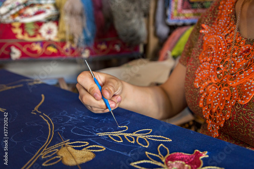 Uzbek woman making embroidery, in Bukhara, Uzbekistan photo