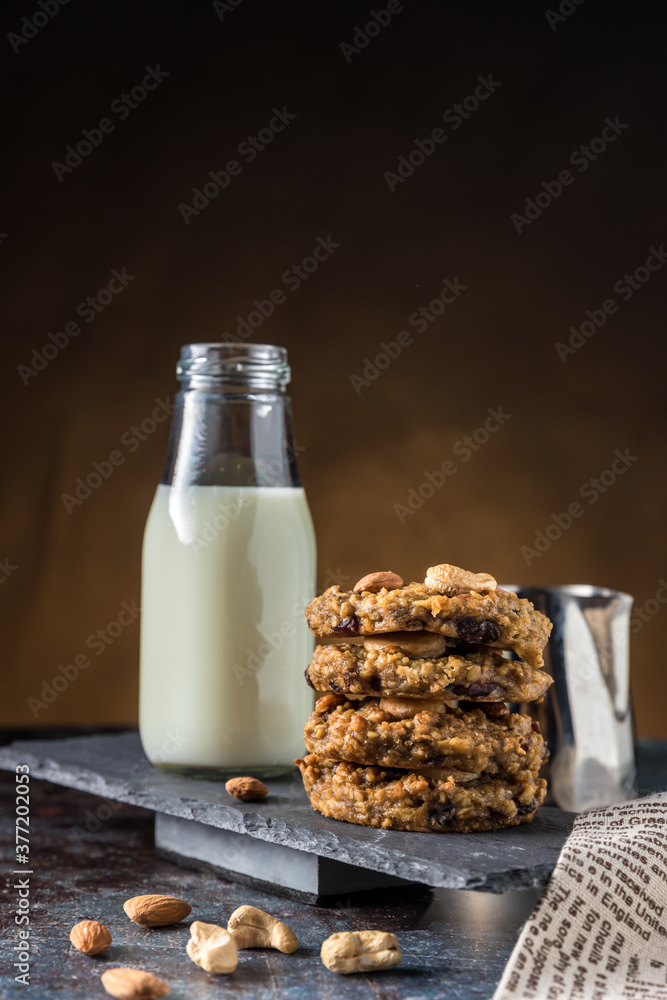 Oatmeal cookies with milk on table. Chocolate chip cookies with milk. Healthy food and drink and natural diet food. Cookie Almond and Cashew nuts. Oatmeal cookies with milk on table. Chocolate chip cookies with milk. Healthy food and drink and natural diet food. Cookie Almond and Cashew nuts.