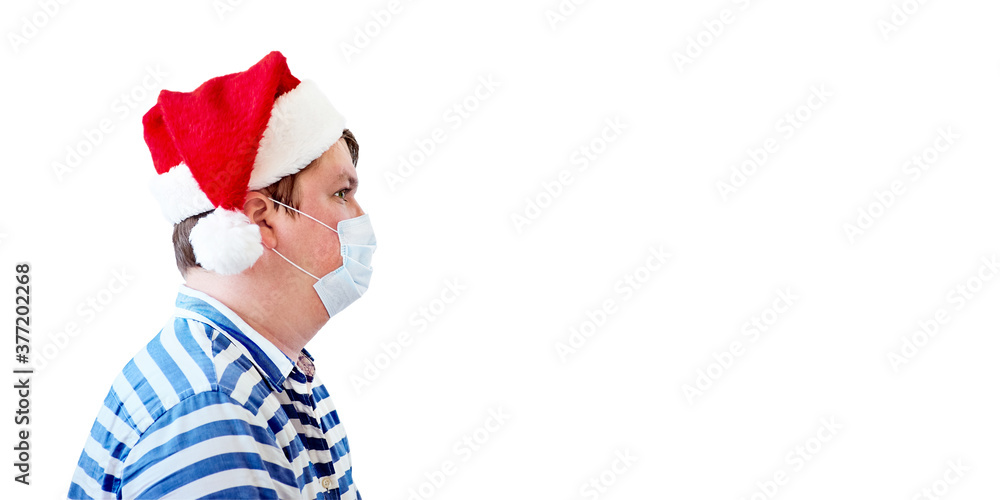 Side view of man with surgical medical mask in red Santa Claus hat isolated on white background. Protection against viruses, infection prevention. Empty copy space for text. Side view of man with surgical medical mask in red Santa Claus hat isolated on white background. Protection against viruses, infection prevention. Empty copy space for text.