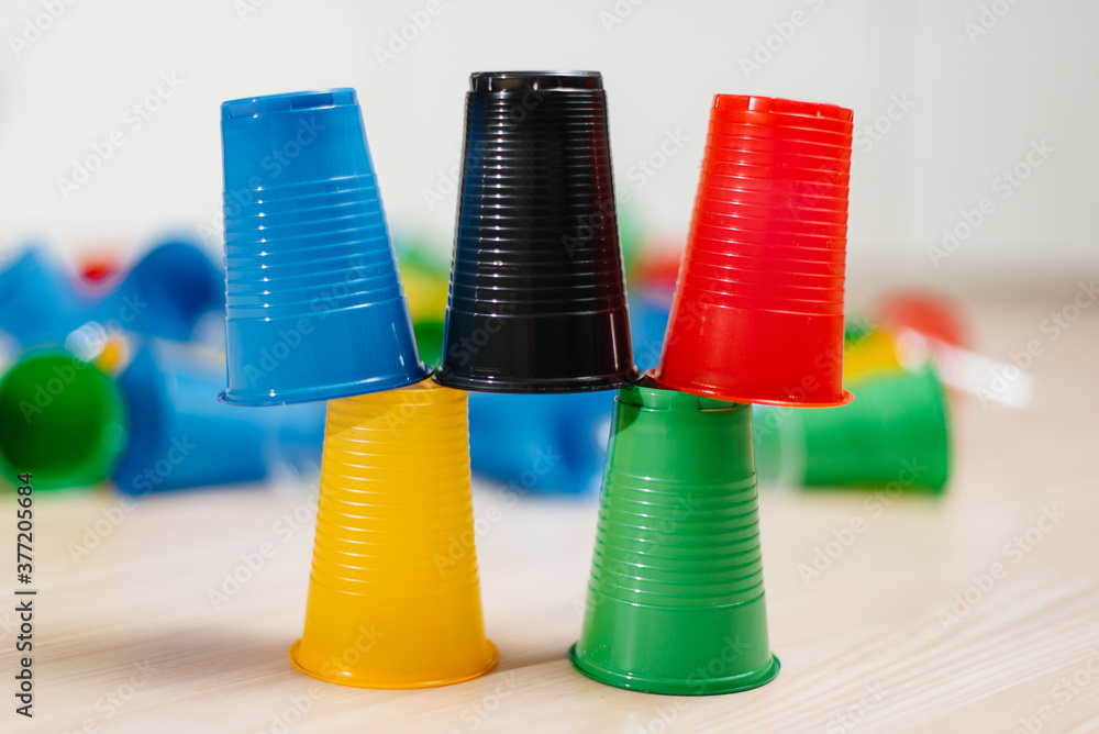 Disposable plastic cups are arranged in a pyramid. Pollution of the environment by human waste Disposable plastic cups are arranged in a pyramid. Pollution of the environment by human waste