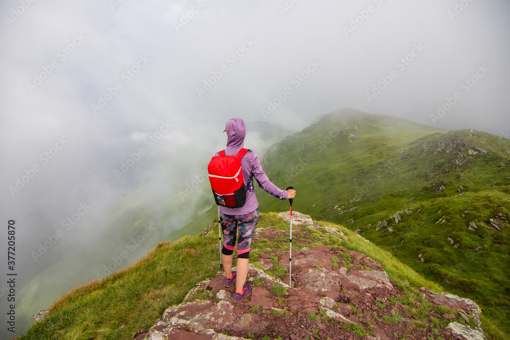  Woman walking in the mountains. Young woman with backpack hiking in the mountains. Stara planina (Old mountain) in eastern Serbia