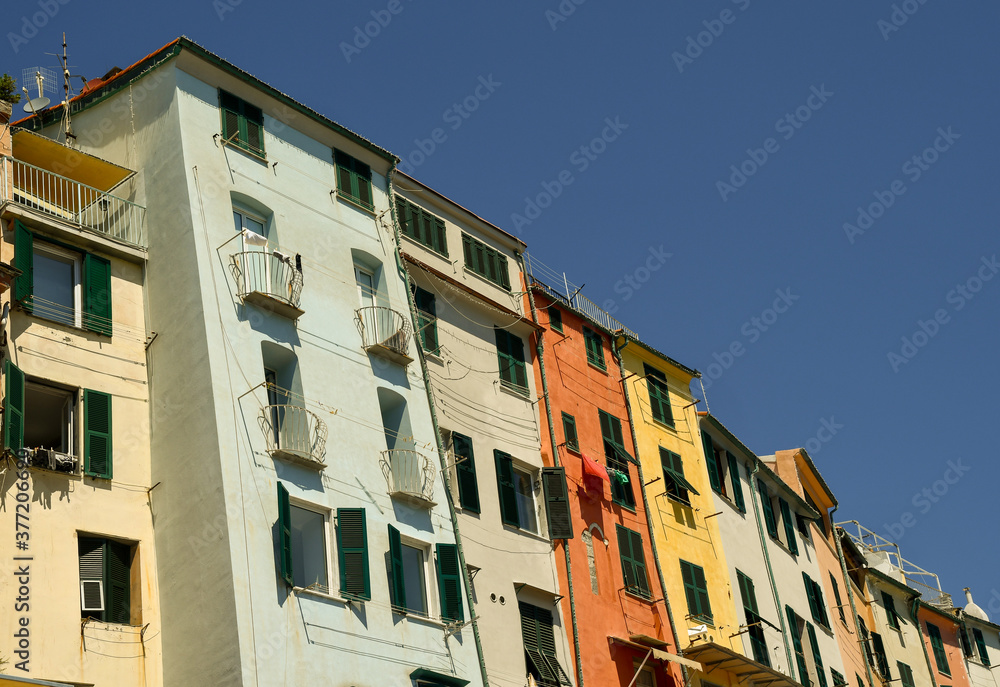 The typical, tall, narrow and colorful old fishermen’s houses of the sea village against blue sky, Porto Venere, La Spezia, Liguria, Italy