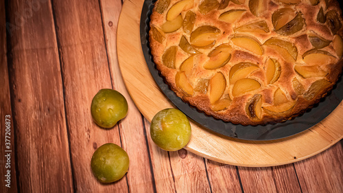 Fresh organic plum cake on the wooden table just made