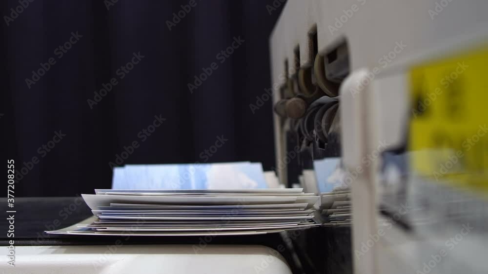 Closeup of printing a pile of paper photo pictures at copy center, print enlargements Closeup of printing a pile of paper photo pictures at copy center, print enlargements