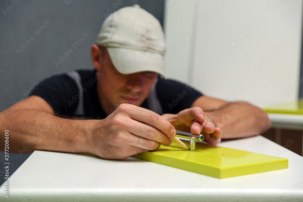 worker assembles furniture in the kitchen. furniture assembly service worker assembles furniture in the kitchen. furniture assembly service