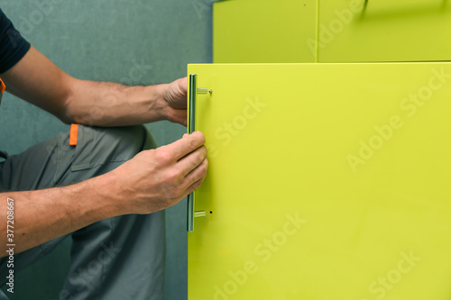 Tableau sur toile worker assembles furniture in the kitchen