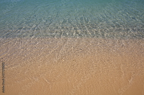 onda che si infrange su una spiaggia di sabbia photo