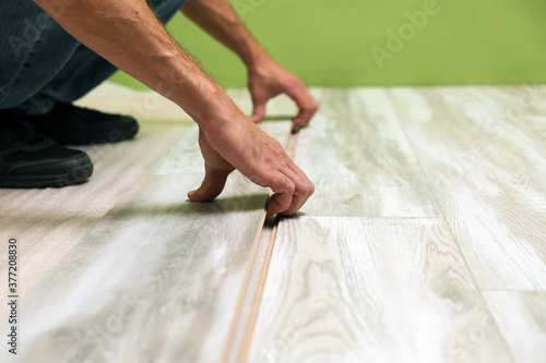 a worker is laying laminate in an apartment. 