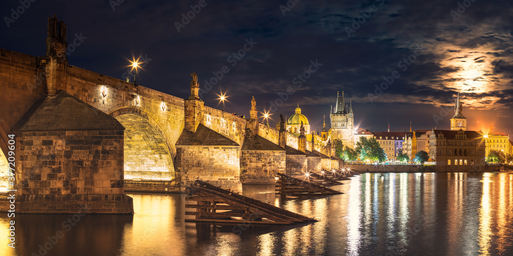 Panorama of Illuminated Charles Bridge, Cultural Monument of the Capital of the Czech Republic, Night Cityscape of the City Center with the River