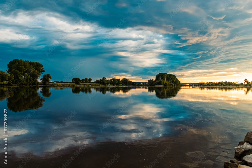 Beautiful sunset with dramatic clouds and reflections near Metten, Danube, Bavaria, Germany