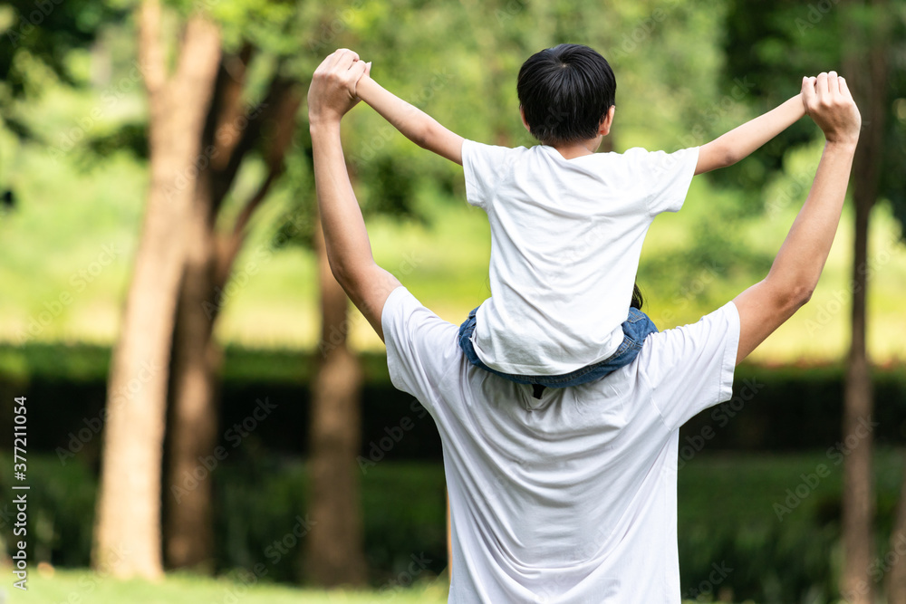 Dad giving son ride on back in the park. Asian family cute and warm. Father and child having fun outdoors. Dad giving son ride on back in the park. Asian family cute and warm. Father and child having fun outdoors.